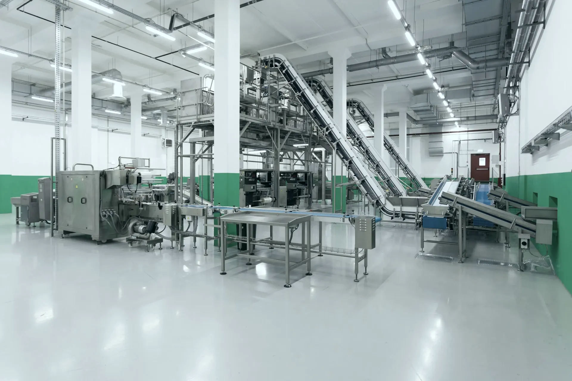 Interior de uma fábrica limpa com esteiras e máquinas de uma linha de produção